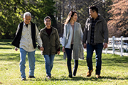 Four members of a family walking together and holding hands.